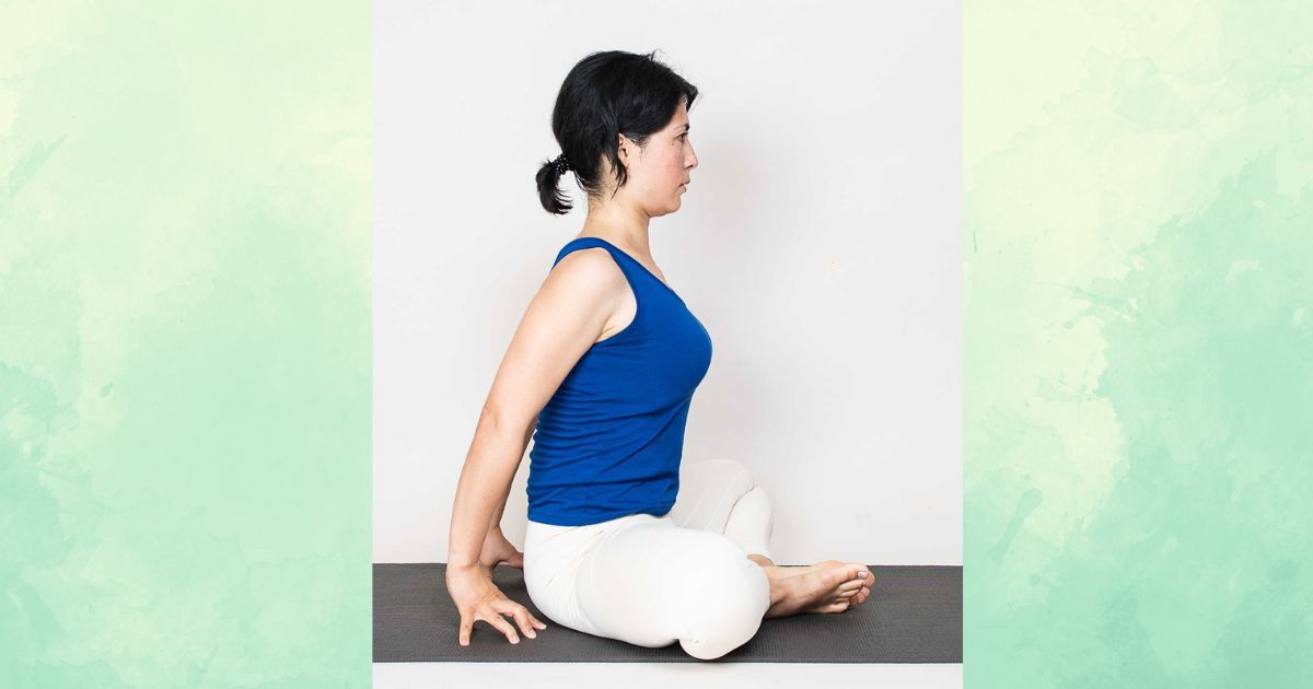 Woman practicing the Bound Angle Pose (Baddha Konasana) taken from the side.